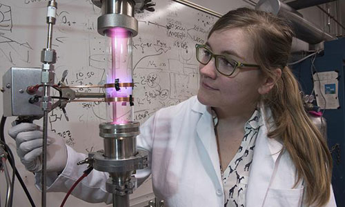 University of Minnesota researcher Samantha Ehrenberg uses a plasma reactor to create silicon nanoparticles that are the key ingredient in the solar concentrators. Credit: Patrick O'Leary, University of Minnesota