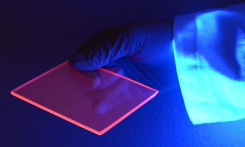While most of the light concentrated to the edge of the silicon-based luminescent solar concentrator is actually invisible, we can better see the concentration effect by the naked eye when the slab is illuminated by a “black light” which is composed of mostly ultraviolet wavelengths. Credit: Uwe Kortshagen, College of Science and Engineering