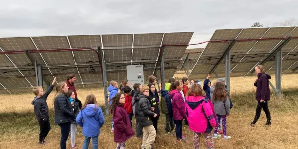 children standing by solar panels