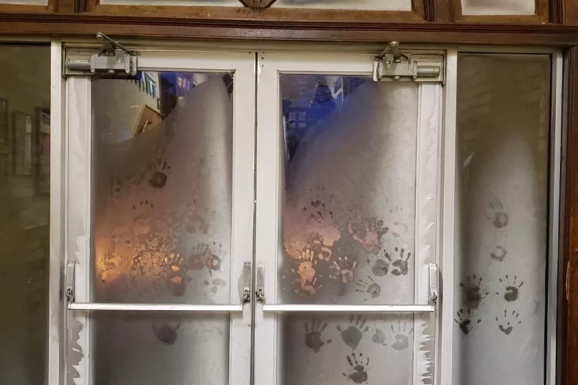 Exterior door to building. Covered in frost and handprints. 