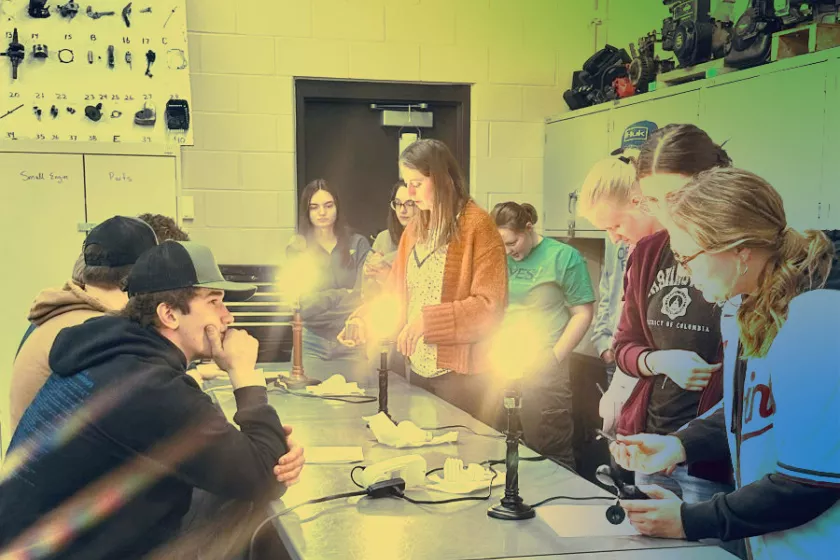 Heidi Auel stands in a science classroom, surrounded by students. 