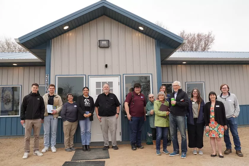 Group photo posing in front of the community building