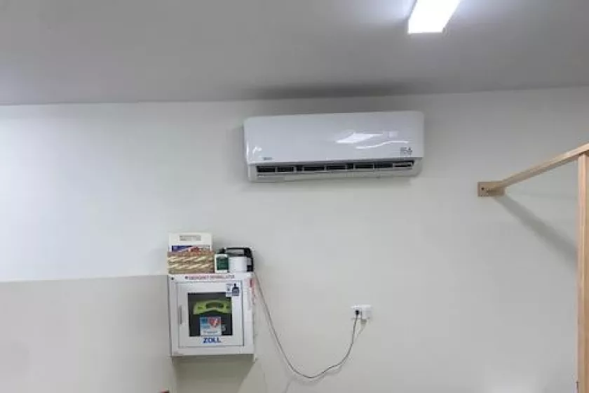 An air handling unit sits mounted on the wall inside the new food shelf space.