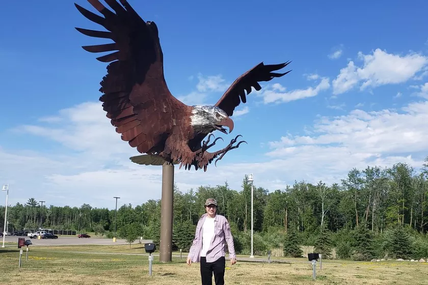 Aaron standing in front of a giant eagle statue