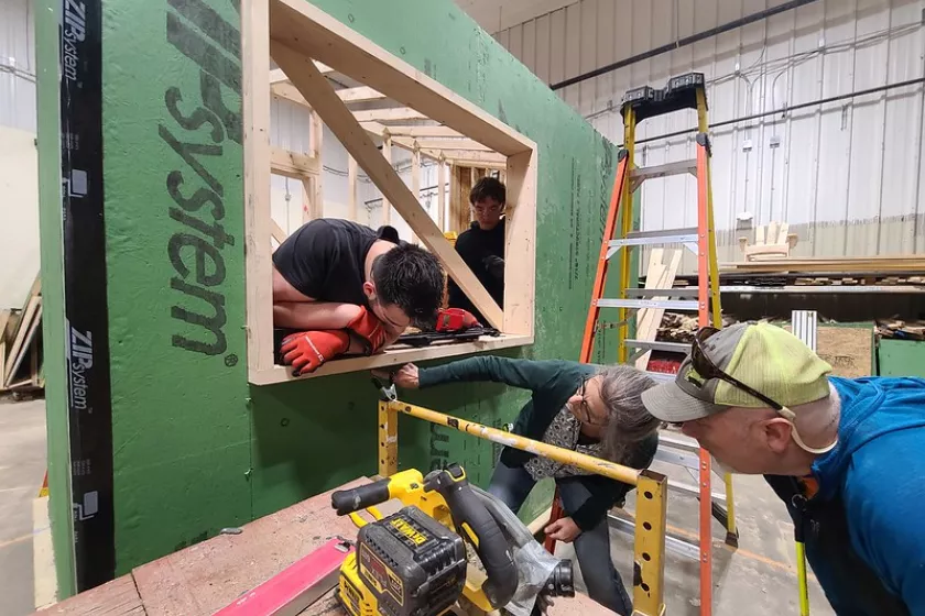 Students work alongside industry professionals and their teachers to build a high-performance structure.