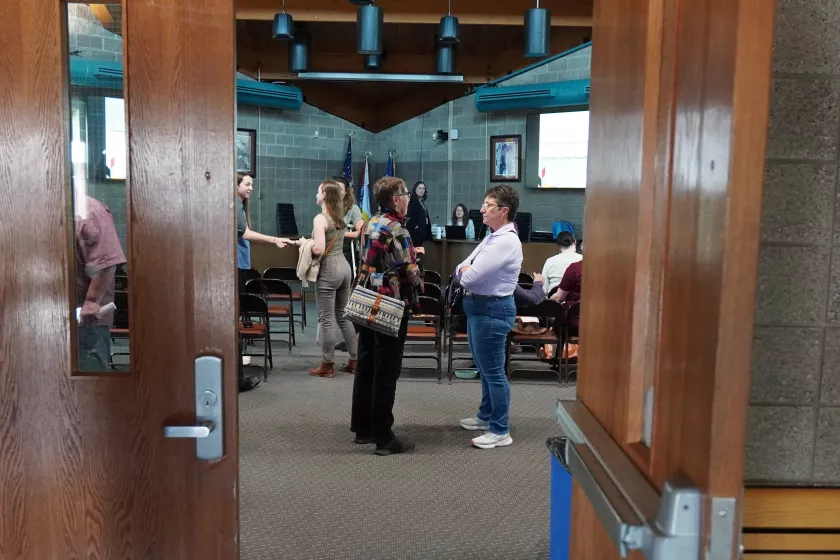 Two attendees talking in the lobby; seen through a doorway