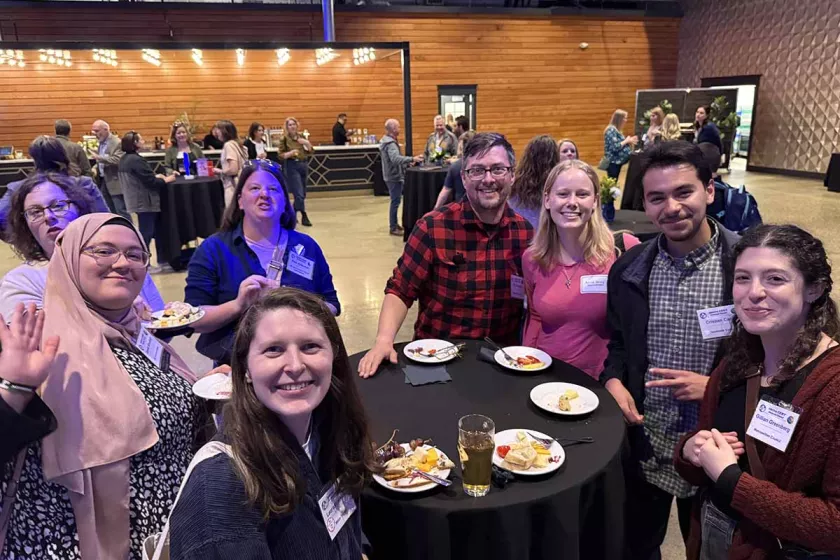 Attendees smiling around a table