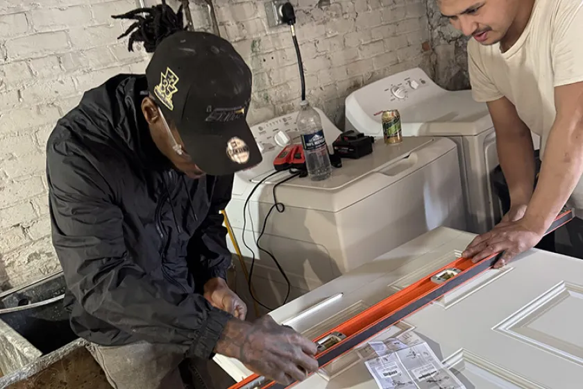 Two Boreal Workers measuring a white door 