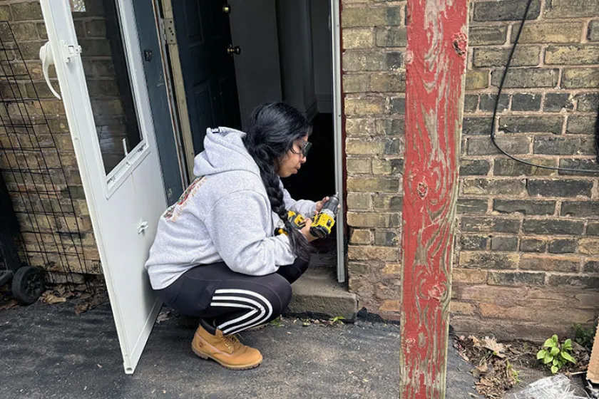 Person screwing weatherstipping onto door frame