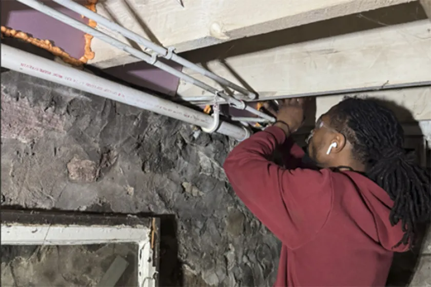 Boreal worker repairing a ceiling corner in the basement