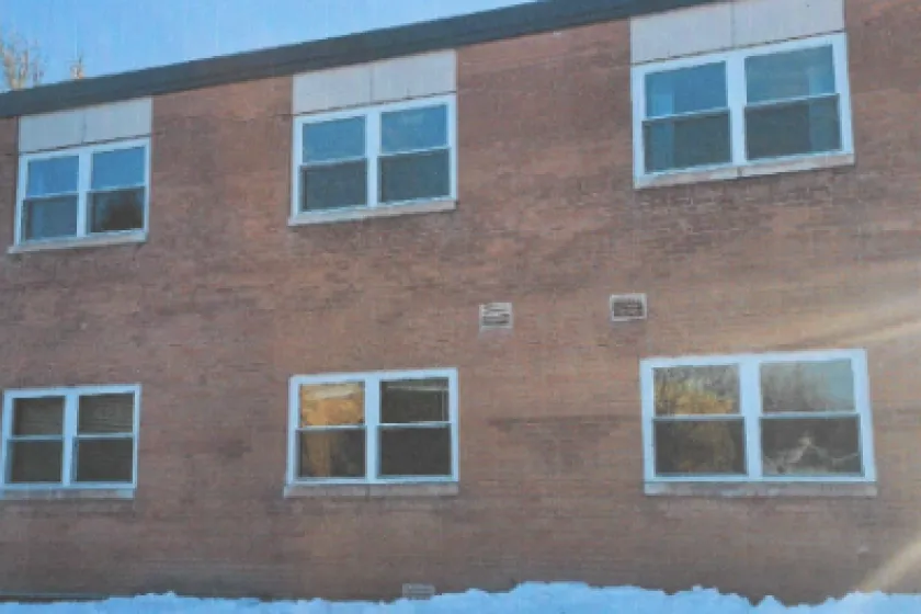 Outside of a brown building with six windows showing 