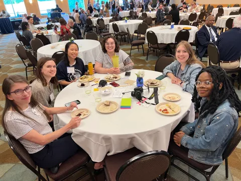 Attendees sitting at a table at the event