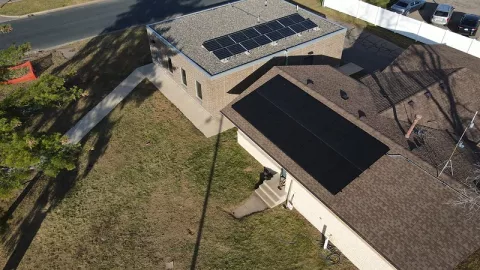 An aerial view of two buildings with solar panels.