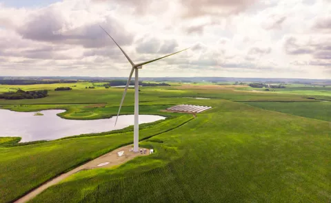 Wind mill stands over a lush green landscape
