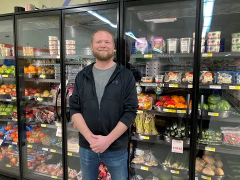 Aaron Bakke standing in front of a refrigerator