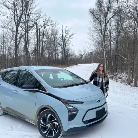 Melissa Birch and her EV by her home.