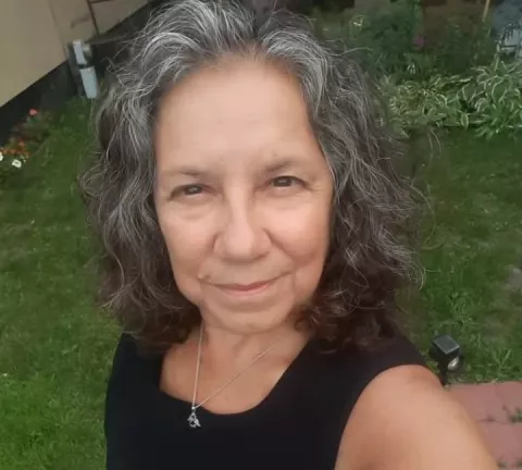 A Latina woman with wavy dark hair.