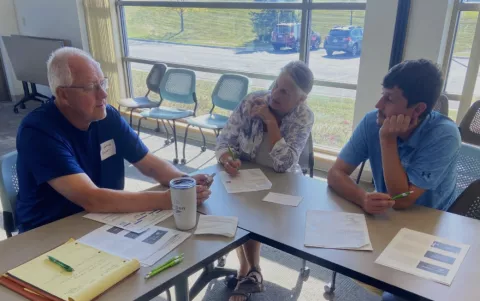 Three people sitting together and discussing at a table