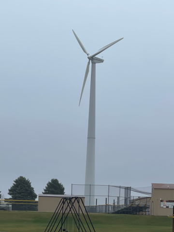 A large outdoor wind turbine set against a blue sky.