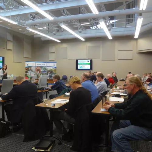 People sitting at tables watching a presentation
