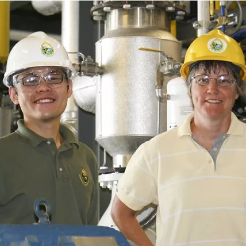 People in hard hats smiling at the camera
