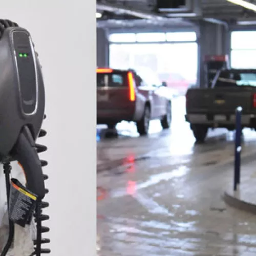 EV charger mounted on a wall in focus with the rest of a parking ramp in the background