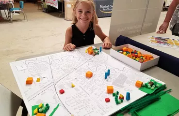 Child with clean energy board at Marshall County Fair