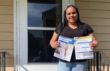 Woman holding energy guides outside of a home