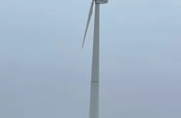 A large outdoor wind turbine set against a blue sky.