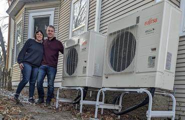 Kristen and William pose outside by their new HVAC system
