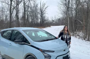 Melissa Birch and her EV by her home.