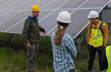 people standing by solar panel