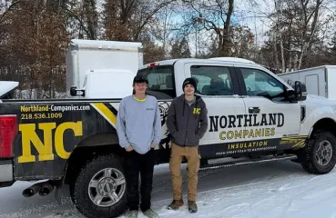 Two Northland crew members posing in front of a pickup truck