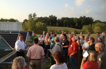 Steve Nisbet from Wright-Hennepin explains to attendees how the solar panel and battery storage systems work.