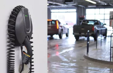 EV charger mounted on a wall in focus with the rest of a parking ramp in the background