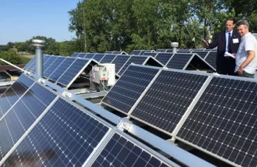Mayor Peter Lindstrom shows off solar panels atop Falcon Heights City Hall