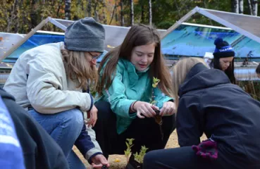Holy Rosary students from Duluth plant pollinator habitat around solar installation at Laurentian Environmental Learning Center