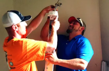 Contractors at the UofM install new LED lights in the hallway