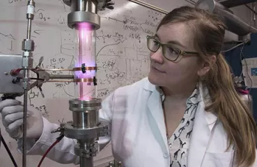 University of Minnesota researcher Samantha Ehrenberg uses a plasma reactor to create silicon nanoparticles that are the key ingredient in the solar concentrators. Credit: Patrick O'Leary, University of Minnesota