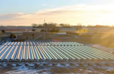 The sun rises over Hutchinson’s new solar PV project, the largest on a landfill in Minnesota, and the first ballast-mounted on a brownfield. Hutchinson’s wastewater treatment facility, the recipient of the array’s electricity, can be seen in the background