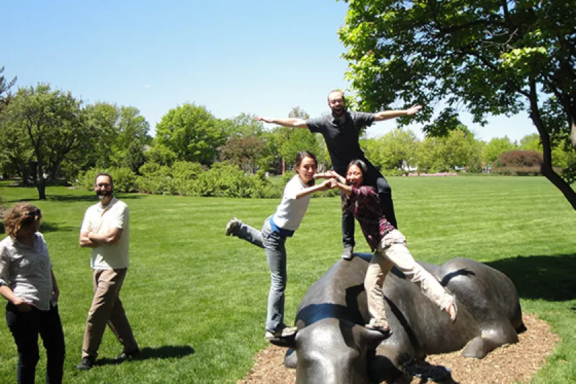 People standing on bull statue