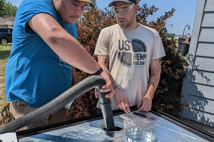 Gasco and a man outside wearing glasses and holding tools