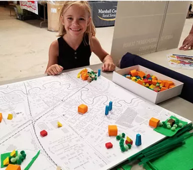 Child with clean energy board at Marshall County Fair