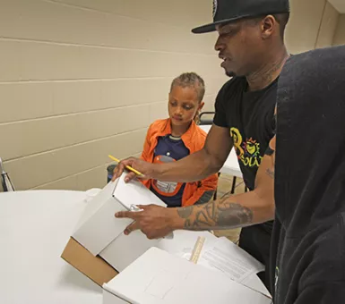 Keith Dent showing camp participants how to create a small solar house