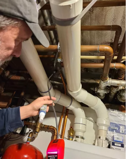 Randy Williams surveys the indoor air quality inside a home, as a part of the assessment. 