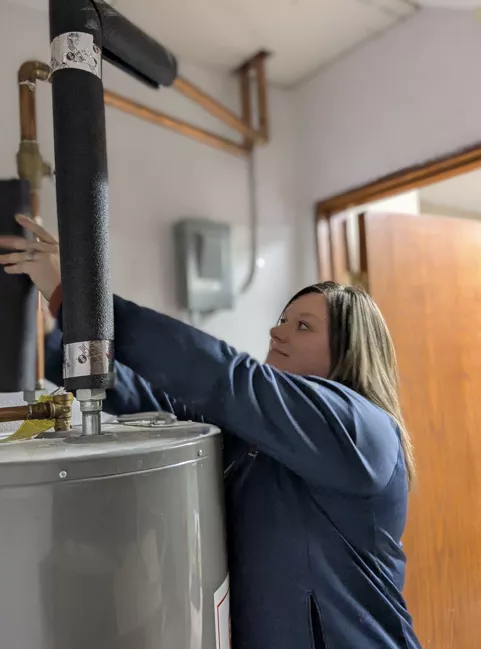 UCAP staff installing pipe wrap for insulation